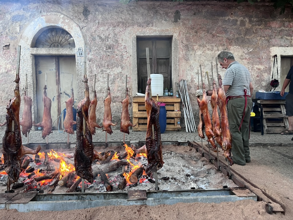 Traditional Sardinian porceddu roasting over an open fire