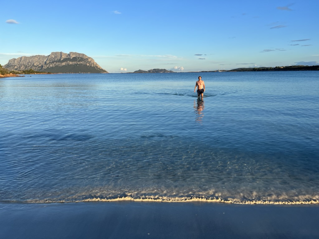 Wading in clear water with Tavolara in the distance